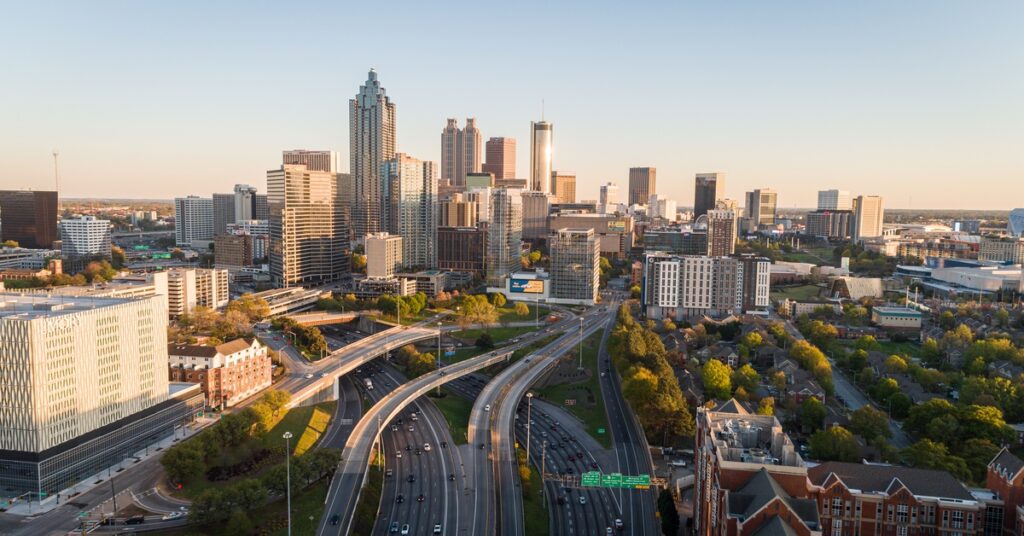 An aerial view of the Atlanta metro skyline, with highways leading to the city center filled with many skyscrapers.